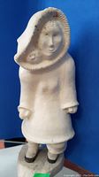 Front view of Inuit carved figurine showing facial details and hooded parka
