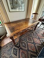 Full view from one corner showing inset leather top and carved legs