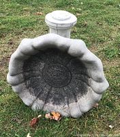 Top-down view of the birdbath basin showing scalloped edge and weathered interior surface.