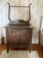 Front view of the antique oak wash stand, showing drawer, cabinet, and towel rack.