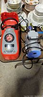 Photo of Black & Decker Air Station air pump and Rocker 300 vacuum pump on floor with dishes in background