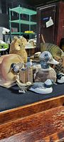 Photo showing several animal figures including a carved owl, wooden duck, and sea-themed carvings