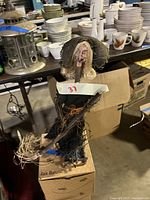 Full view of Halloween witch sculpture on wooden base among other household items.