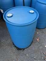 Full view of single blue plastic rain barrel standing on ground with visible measurement marks.