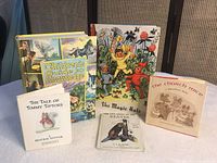 Five assorted children's books arranged upright and flat, showing cover artwork and titles.
