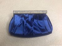 Front view of blue satin clutch purse with rhinestone frame and pleated fabric