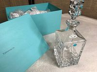 Decanter placed next to original Tiffany & Co blue box, showing the overall lot contents and packaging.