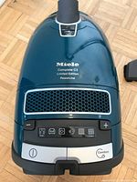 Top-down view of vacuum body showing Miele branding, control panel and model text