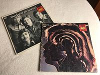 Photo of The Best of Bread and Rolling Stones music books on a white surface, showing covers and wear.