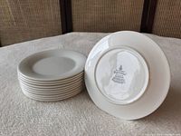 Stack of 10 white bread plates with one plate showing the underside marking of Royal Doulton Expressions Silhouette English china.