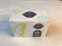 Closed white box with butterfly and flower graphics labeled Scentsy Fragrance Flower.
