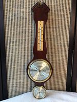 Front view showing the wooden barometer with thermometer on top, barometer in center, and hygrometer at bottom.