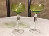 Front view of two green etched stem glasses showing detailed designs and clear stems.