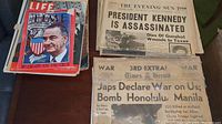 Photo showing a stack of magazines including Life and Time, and newspapers including The Evening Sun with headline about JFK assassination