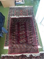 Two oriental style area rugs stacked, showing size comparison with visible fringes and pattern detail.