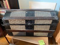 Full view of the vintage wooden and metal decorative trunk showing the pattern and wooden slats.