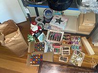 Overview of lot items on floor and shelf including ornament boxes, Santa bank, ceramic tree, greeting card squares, decorative plates, star topper