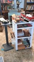 Wide view showing metal work stand with tools on and around it, and the separate mounting stand beside it.