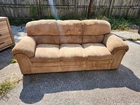 Front view of beige corduroy sofa showing three seat cushions and cushioned armrests
