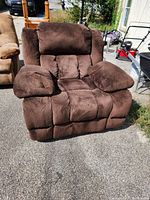 Front-facing view of the large brown recliner showing plush cushioned armrests and backrest.