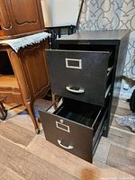Metal 2 drawer file cabinet with one drawer open showing interior storage space, showing condition and features