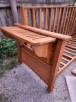 Photo of one armrest piece of the disassembled futon frame, showing wood grain and side structure