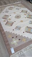 Full view of the area rug showing the complete geometric design and fringed edges.