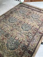 Full view of the floral patterned area rug lying flat on the floor.