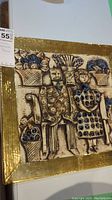 Front view of ceramic plaque showing seated male and female figures, floral vases, cobalt blue accents and gold border