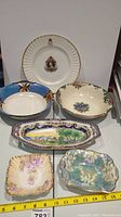 All six collector plates and bowls arranged with ruler showing size alignment
