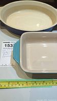 Two ceramic casserole dishes shown side by side with measuring tape showing approximate dimensions.