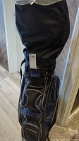 Full view of the Playday golf bag covered with a black rain cover or protective sleeve.