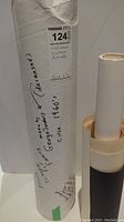 White protective tube labeled as containing vintage posters by Saunders from the 1960s.