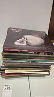 Stack of vinyl records viewed from the side with Cher album on top.
