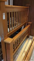 Side view photo showing the wooden headboard with vertical slats and squared posts.