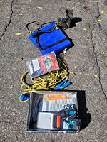Photo of miscellaneous items including yellow rope with blue handles, blue folding chair, water filter, and metal tray with tools and zip ties