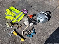 Entire lot arranged on pavement showing all included items including safety vest, tools, radio, fittings