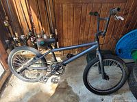 Side view of the black Mongoose trick bike showing frame, front tire, seat and handlebars.