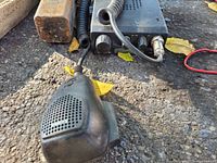 Close-up of CB radio and microphone on asphalt ground with some leaves