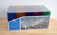 Photo showing the 50-pack box with five stacks of slim CD/DVD jewel cases in colors blue, orange, purple, red, and green, all sealed in plastic wrap.