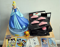 Disney lot items including Cinderella coin bank, Vinylmation figure, Little Mermaid clip barrettes, Disney playing cards and patches, PopSockets grips and match pack