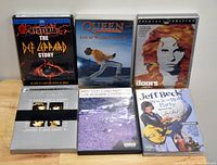 Photo of seven music DVDs from classic rock and blues artists including The Doors, Queen, Def Leppard, Jeff Beck, Red Hot Chili Peppers and Beatles.