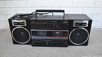 Full front view of the Fisher PH-W702 boombox showing speakers, cassette decks, control panel, and handle.