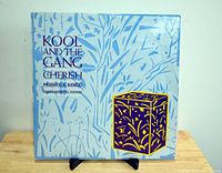 Front cover of Kool and the Gang's Cherish / Fresh (U.S. Remix) vinyl record featuring blue patterned design with text and illustration.