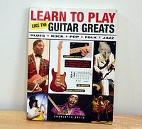 Front cover of Learn To Play Like The Guitar Greats soft cover instructional guitar book showing photos of guitarists, a red electric guitar illustration, and text about blues, rock, pop, folk, and jazz styles.