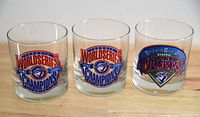 Front view of three clear glasses with Toronto Blue Jays 1993 and 1992 World Series champion logos and text printed on them.