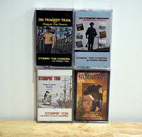 Four Stompin' Tom Connors cassette tapes in plastic cases with distinct cover art.