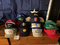 Front view of the collection showing placement and variety of 18 caps in different colors and logos