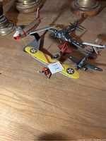 Vintage model fighter planes displayed on wooden surface with two lamps in background