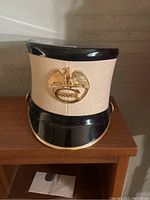 Full frontal view of the vintage Culver Military Academy hat showing cream felt crown, gold eagle badge labeled 'CULVER', black top and glossy black visor with gold rope trim.